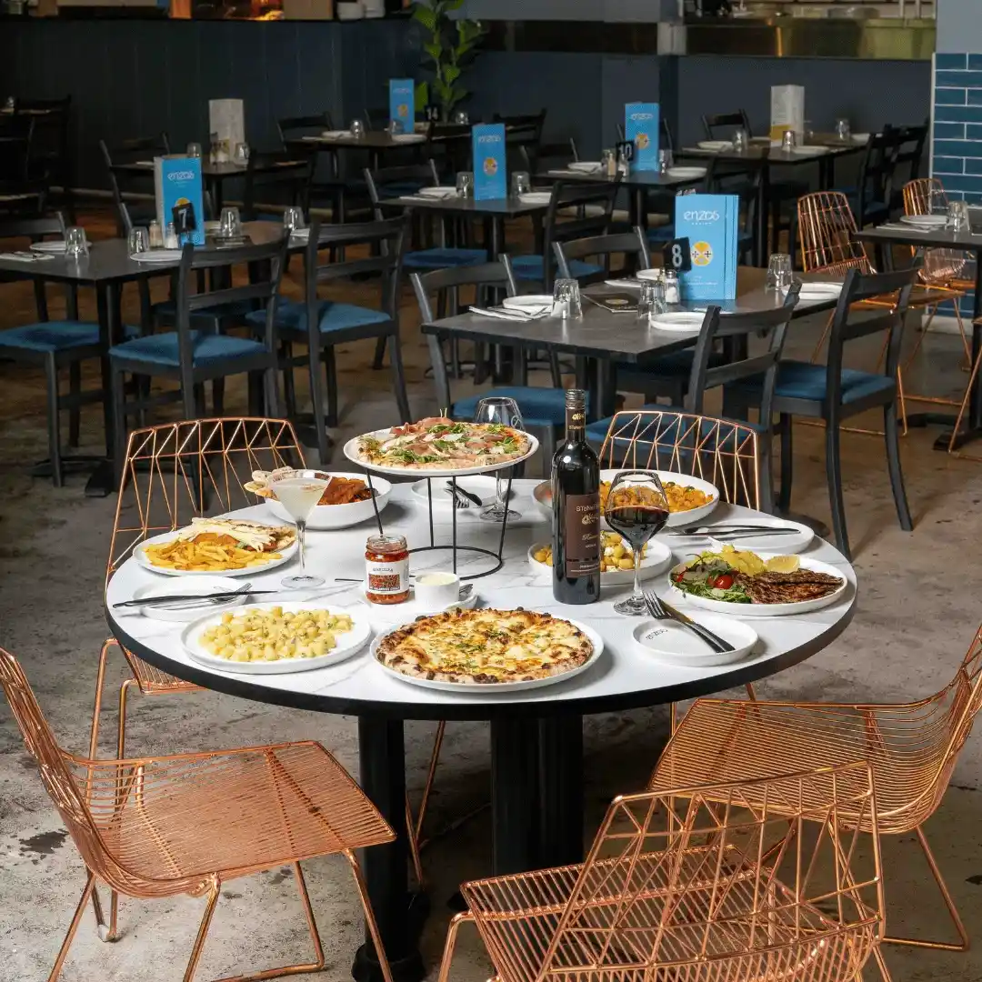Pizza, pasta, and wine dining setup at Enzo's Cucina Carrara.