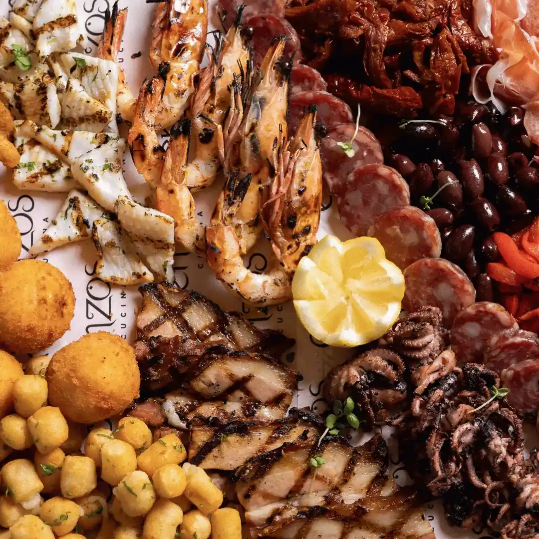 Gourmet antipasto platter from Enzos Cucina featuring grilled prawns, calamari, cured meats, olives, cheese and roasted vegetables