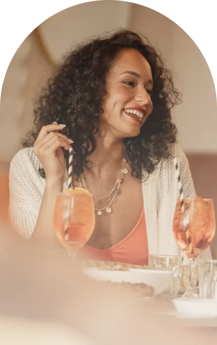 Guest smiling with an Aperol spritz at Enzo's Cucina